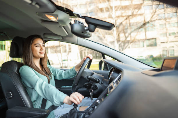 istock Smiling young woman driving car 1480520711