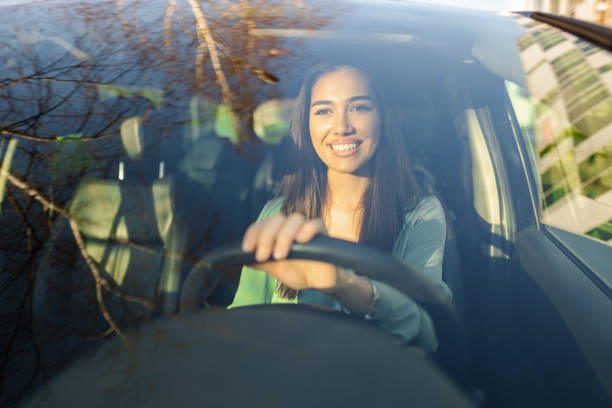 istock Smiling young woman driving car 1480520816