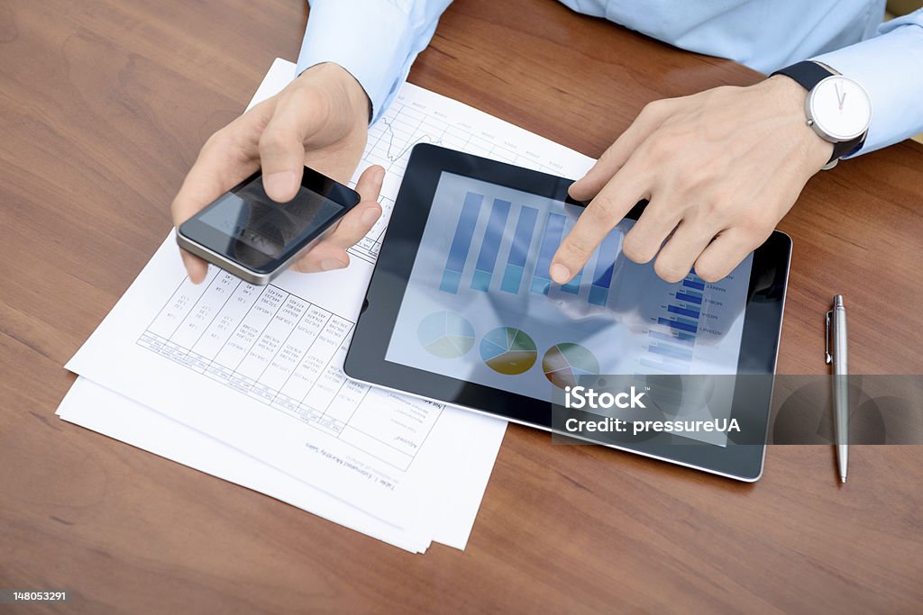 Man working with modern devices Young businessman working with modern devices. Adult Stock Photo