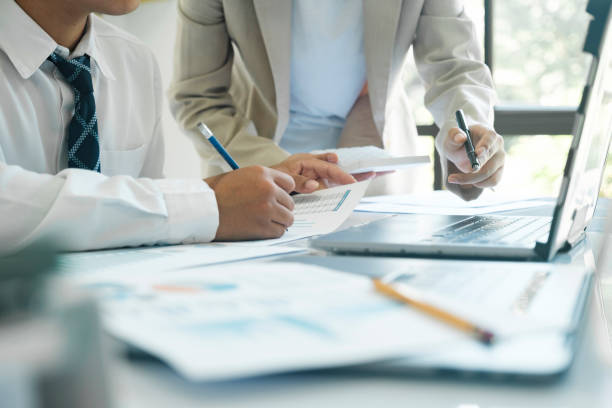istock Close up businesspeople are working by discuss and analyses their project by using laptop and calculator. 1480533411