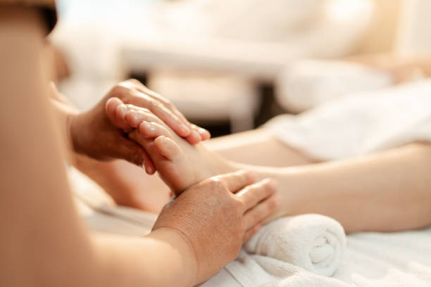 крупный план ручной массажистки для массажа ног женщине-клиенту. - alternative therapy body care stretching thailand стоковые фото и изображения