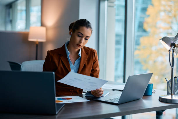 istock Female entrepreneur analyzing business reports while working in the office. 1480534587