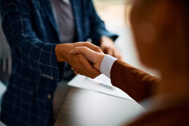 Close up of business people shaking hands in the office. Close up of coworkers handshaking while greeting during business meeting in the office. job interview stock pictures, royalty-free photos & images