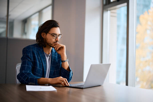 istock Pensive businessman reading an e-mail on laptop in the office. 1480536270