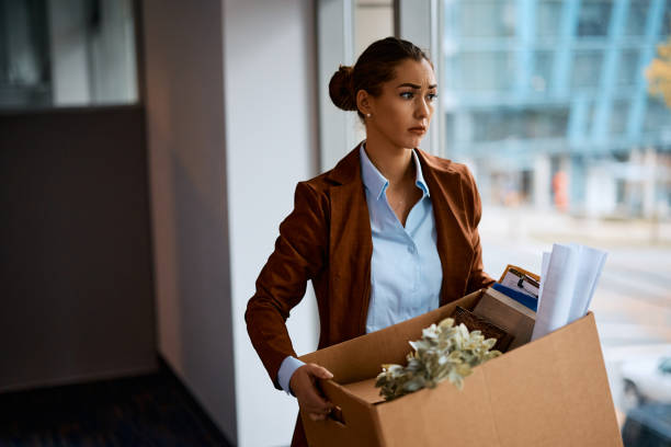 distraught entrepreneur carrying her belongings after being fired from work. - firing unemployment downsizing box imagens e fotografias de stock