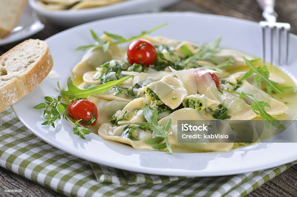 Stuffed pasta Italian pasta stuffed with spinach and quark,  a South Tyrolean specialty so-called  Schutzkrapfen,   served with rucola butter sauce Arugula Stock Photo