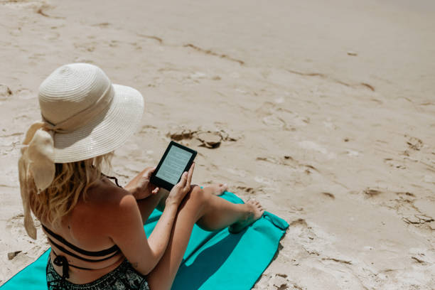 istock Woman Relaxing at Beach on Chair with Electronic Book Reader 1480539652