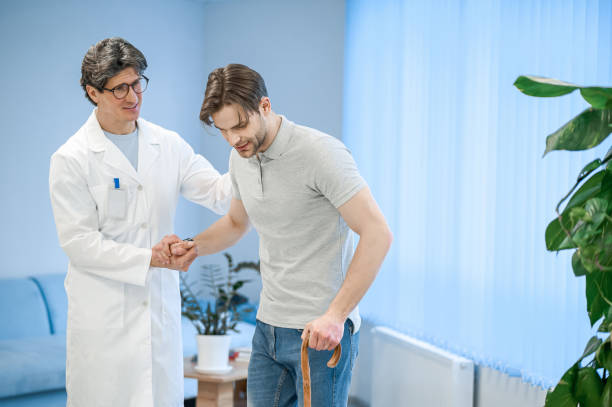 istock Nurse assisting a patient to walk with a stick 1480545050