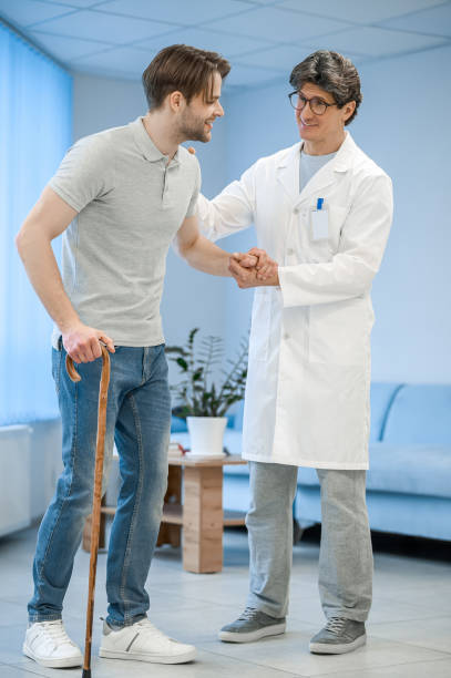 istock Nurse assisting a patient to walk with a stick 1480545053