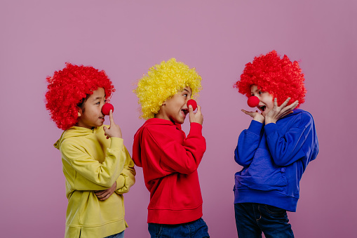 Happy children playing on clown, studio shoot.