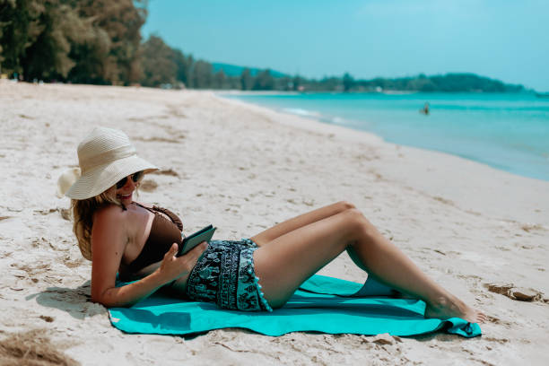 istock Woman Relaxing at Beach on Chair with Electronic Book Reader 1480545830
