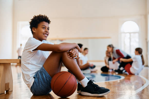 istock Happy African American student relaxing on the floor during PE class at school. 1480546967