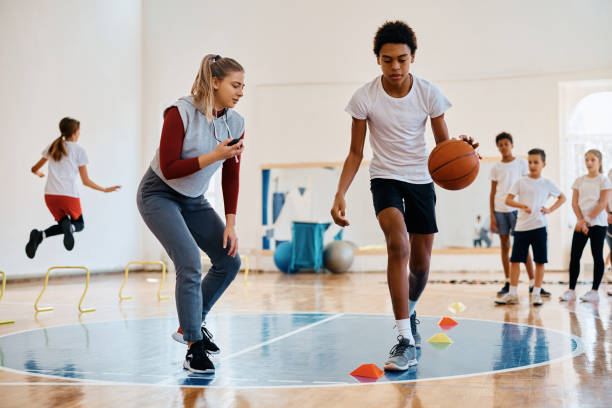 istock Black boy leading a basketball during physical activity class at school gym. 1480547047