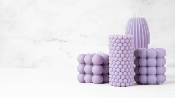 istock Handmade olive wax different forms lilac, purple color candle on a on the white marble table at home. Sustainability vegan candle, natural materials. Minimalistic photo. Copy space. Horizontal Banner 1480547218