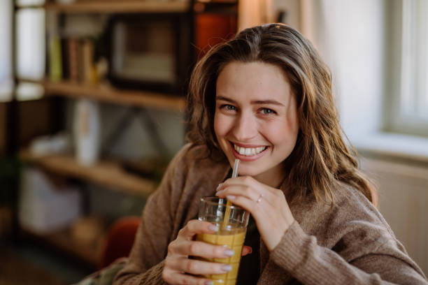 istock Young woman sitting on sofa with drink. 1480551314