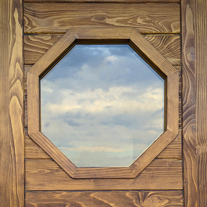 Hexagonal window with natural wood frame