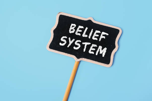 istock BELIEF SYSTEM - text on a small chalkboard on a blue background. Top view. Business, tips and tricks concept 1480553116
