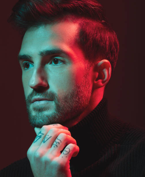 istock Idea, fashion and red with a handsome man model in studio on a dark background for contemporary beauty. Face, thinking and art with a young male posing indoor to promote trendy clothes or style 1480554957