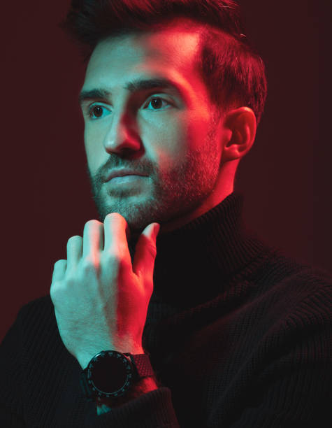 istock Idea, beauty and red with a handsome man model in studio on a dark background for contemporary fashion. Face, thinking and art with a young male posing indoor to promote trendy clothes or style 1480554959