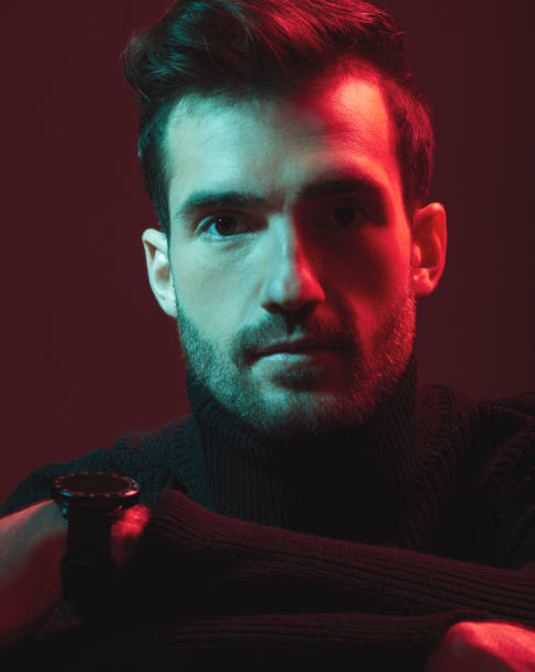 istock Portrait, serious and red with a handsome man model in studio on a dark background for contemporary fashion. Face, beauty and art with a young male posing indoor to promote trendy clothes or style 1480554960