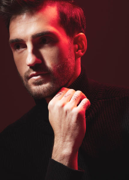 istock Thinking, fashion and red with a handsome man model in studio on a dark background for contemporary beauty. Face, idea and art with a handsome male posing indoor to promote trendy clothes or style 1480554963