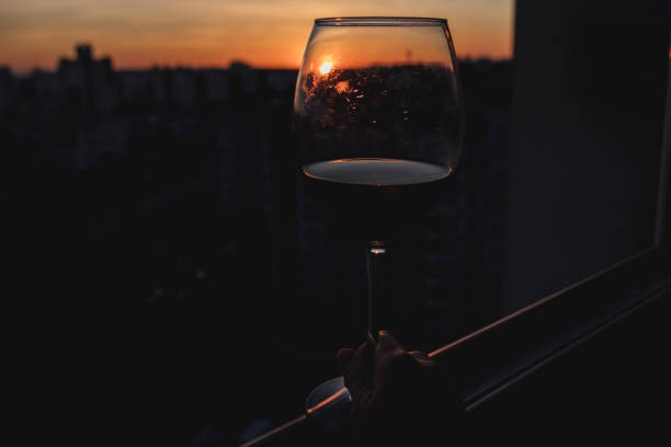 istock Hand holding glass of wine on sunset. 1480555006