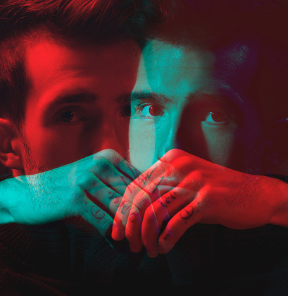 Man, face and hands with double exposure, portrait with neon lighting and fashion overlay, dark with special effects. Color, creative aesthetic and style, art and cosmetics with reflection
