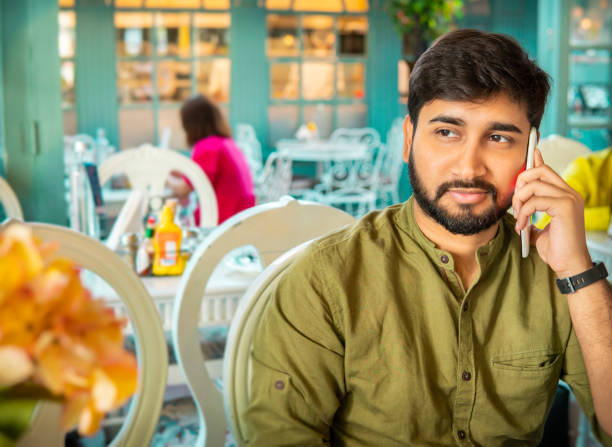 istock Happy young man talking on phone in the cafe. 1480560154