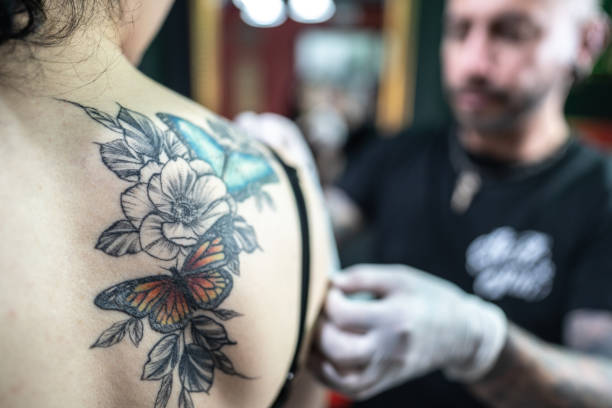 Tattoo artist pasting the decal on the customer at tattoo studio