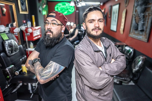Portrait of small business owner partners at tattoo studio