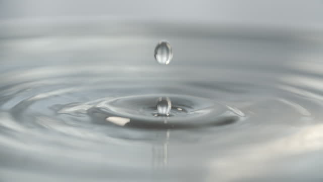 Water drops on grey background macro slow motion