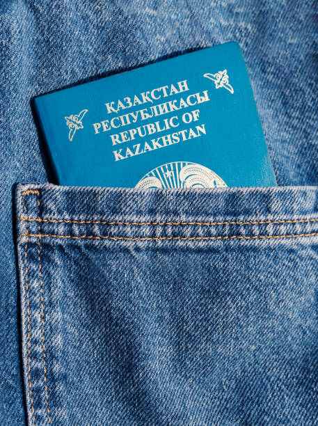 Kazakhstan passport close up in a blue jeans back pocket. KZ passport document. Vertical photo Kazakhstan passport close up in a blue jeans back pocket. KZ passport document. High quality vertical photo jeans denim passport pocket stock pictures, royalty-free photos & images