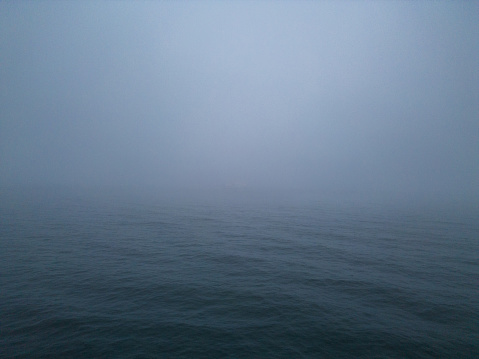 atmosphere of a sea at night and fog. The combination of the dark setting and the foggy conditions can create an eerie and mysterious environment that may be unsettling or fascinating to observe.