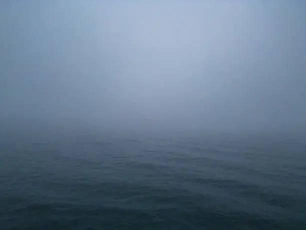 atmosphere of a sea at night and fog. The combination of the dark setting and the foggy conditions can create an eerie and mysterious environment that may be unsettling or fascinating to observe.