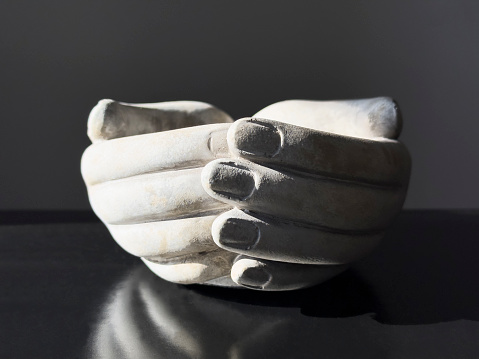 Decorative female hands of a mannequin protruding from the wall. One hand holds a pencil, the other points.3d illustration. Render.
