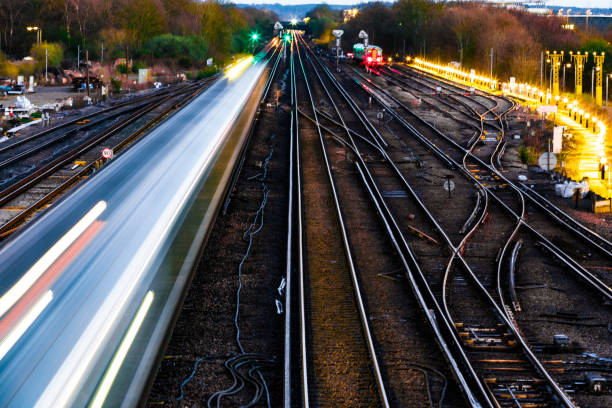 Blurred motion of passenger train in early evening High angle view of blurred motion and light trails of a passenger train in the early evening. gatwick airport photos stock pictures, royalty-free photos & images