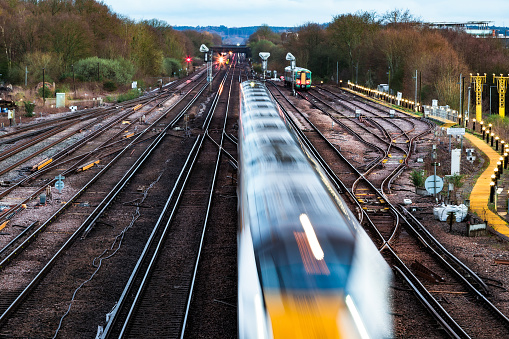 High angle view of blurred motion and light trails of a passenger train in the early evening.