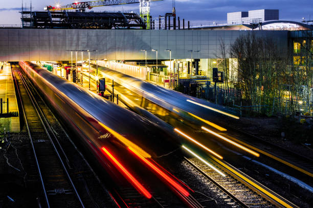 Blurred motion of passenger train in early evening High angle view of blurred motion and light trails of a passenger train in the early evening. gatwick airport photos stock pictures, royalty-free photos & images