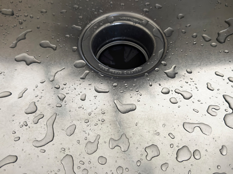 water flowing into gray washbasin drain