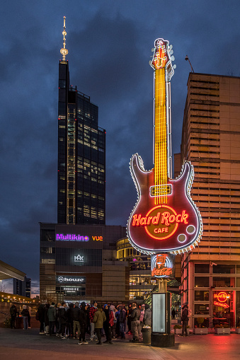 Illuminated hard rock cafe guitar during night seen from Emilii Plater street, Warsaw, Poland. With surrounding commercial buildings. 4 april 2023, Warsaw, Poland.