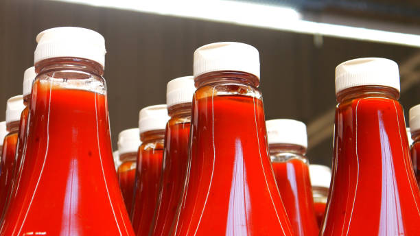 Close-up of many beautiful bottles of ketchup or tomato sauce in a supermarket stock photo