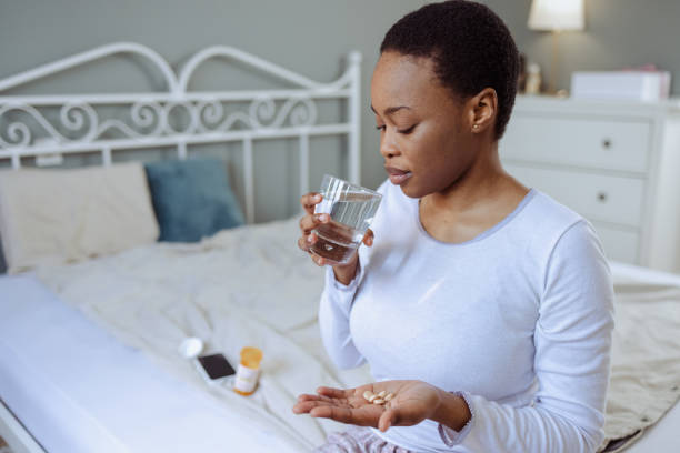 istock Young woman taking medicines in bed 1480574855
