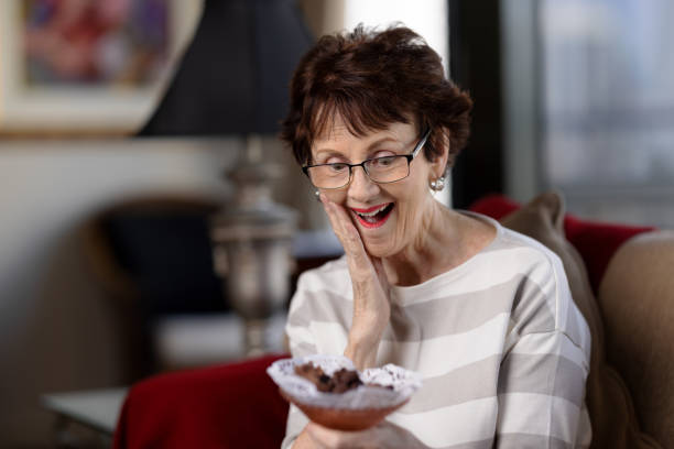 istock Senior woman with excited expression about to eat chocolates 1480580484