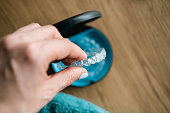 Woman's hand holding  invisible aligners.