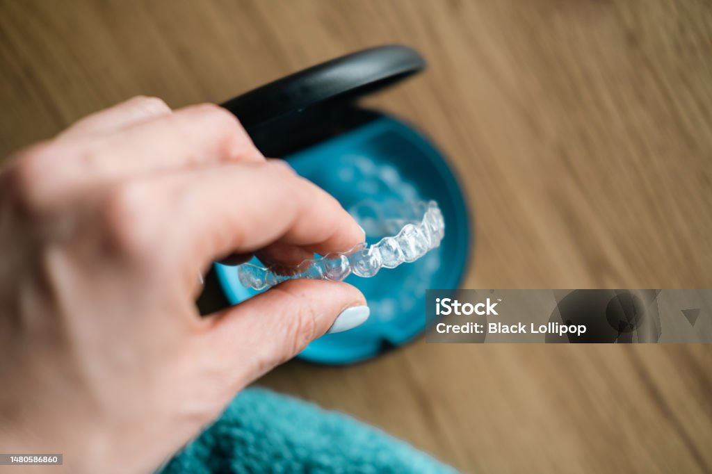 Woman's hand holding  invisible aligners. Invisible braces close up. Dental Aligner Stock Photo