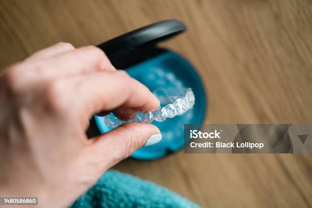 Womans Hand Holding Invisible Aligners Stock Photo - Download Image Now - Dental Aligner, Dental Braces, Orthodontist