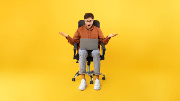 istock Shocked Man Using Laptop Working Online Sitting On Yellow Background 1480589616