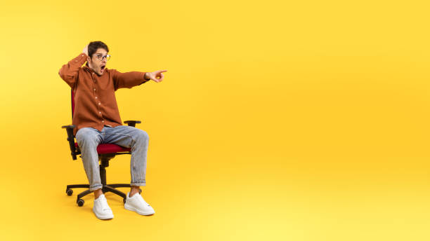 istock Shocked Man Pointing Finger Aside At Empty Space, Yellow Background 1480589785