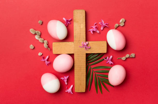 istock Pink Easter eggs with cross and leaves on color background, top view 1480590097