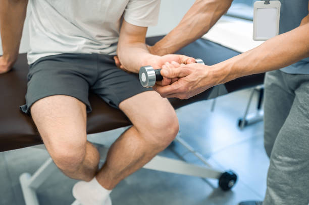 istock Male patient sitting on a couch and exercising his arm 1480590163